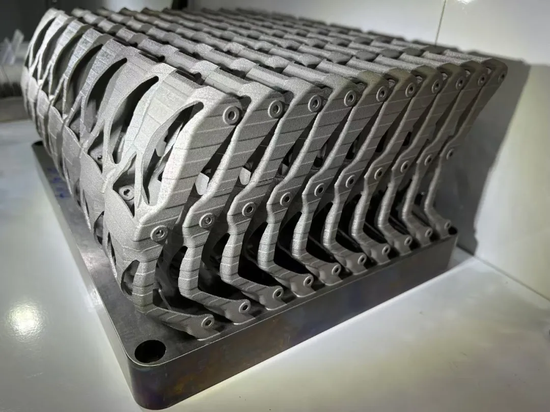 Generative metal AM C-brackets nested in a batch still on the build plate