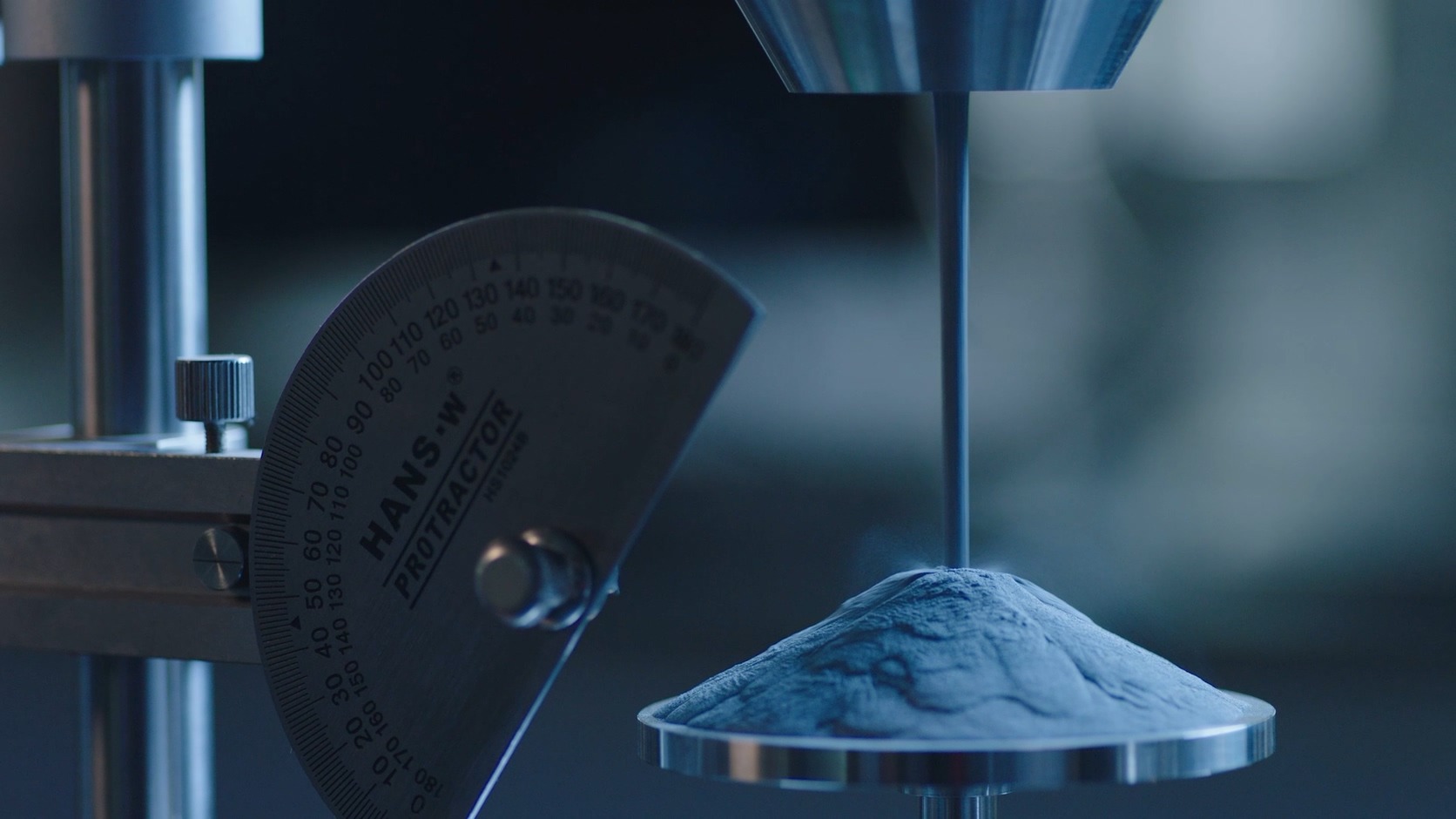 Laboratory setup measuring metal AM powder angle of repose with a falling powder cone