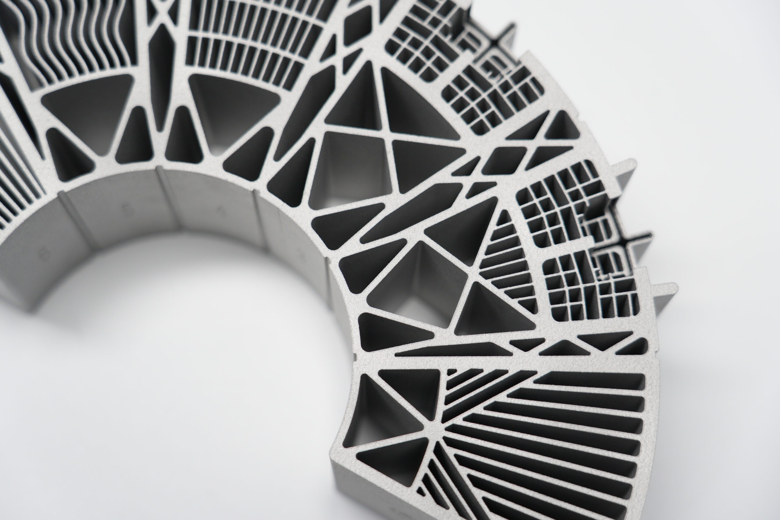 Close-up of segmented metal AM arch with lattice trusses and wavy fin channel coupons