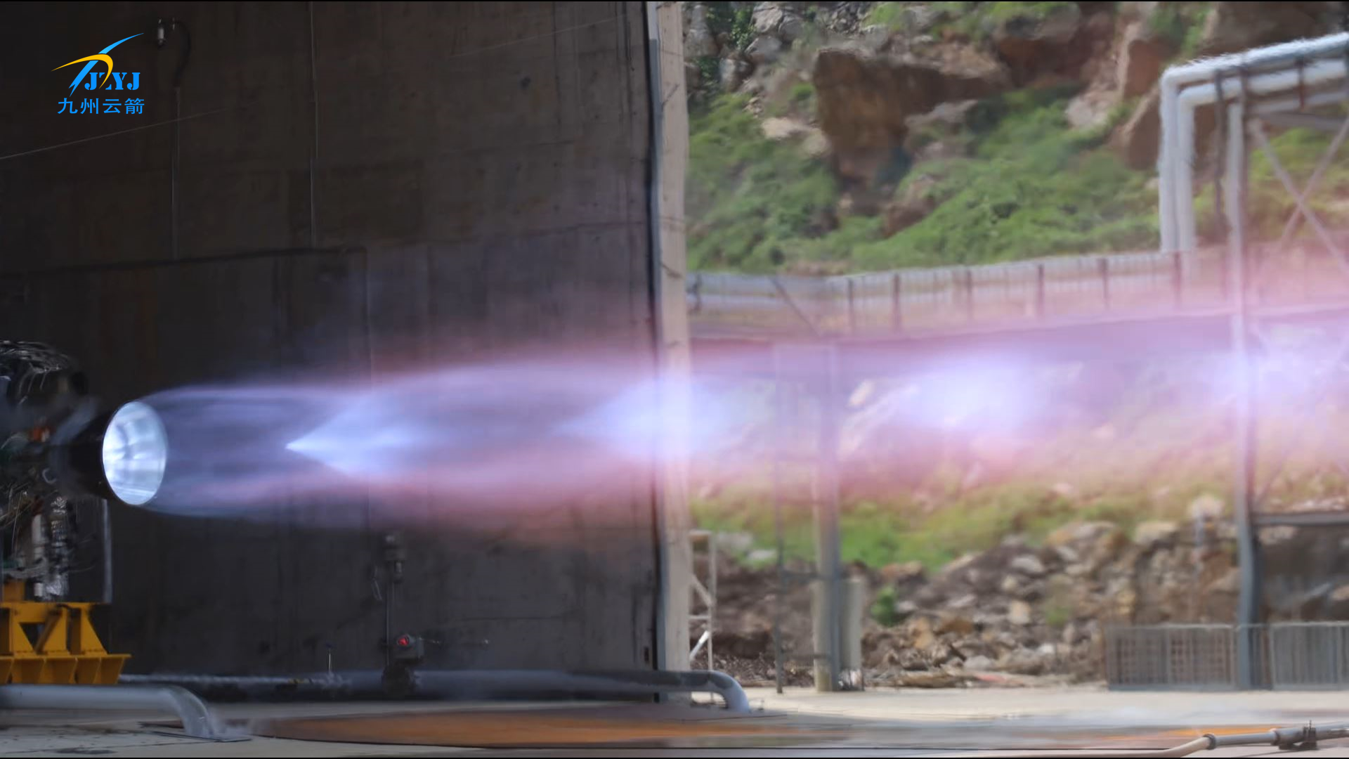 Liquid rocket engine nozzle during an outdoor static-fire test with visible exhaust plume