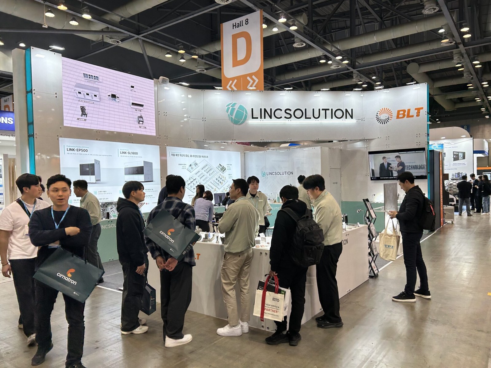 Trade-hall booth context photo for metal additive manufacturing partner discussions