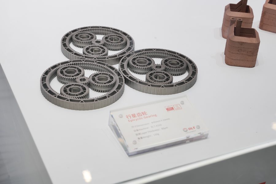 Three metal additive planetary gear sets with lattice spokes on a white table