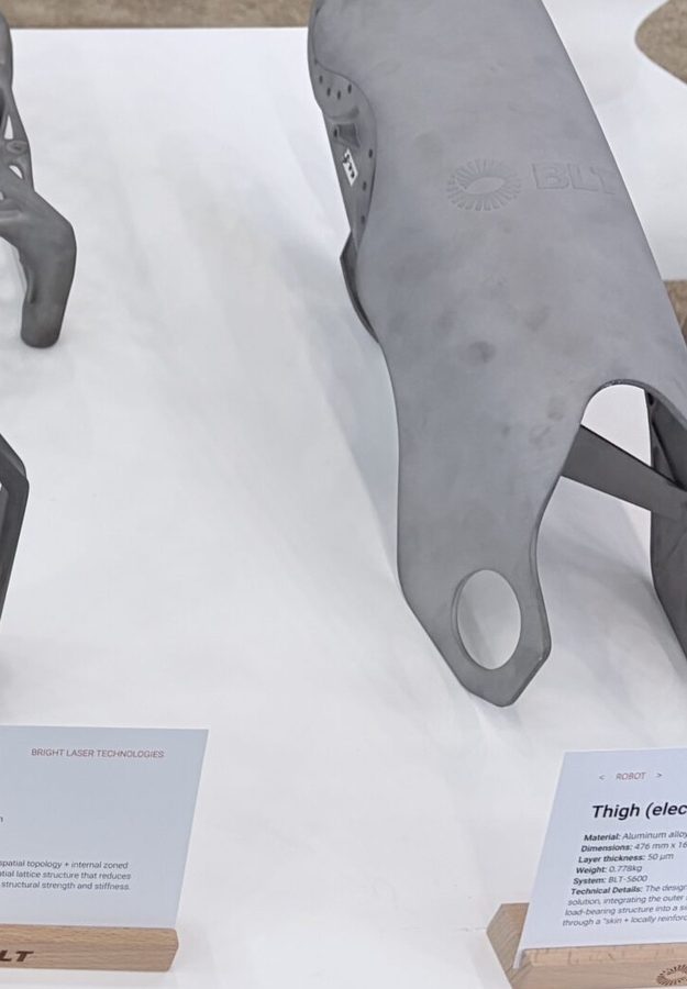 Aluminum additive robot thigh shell blank with internal lattice on an exhibit table